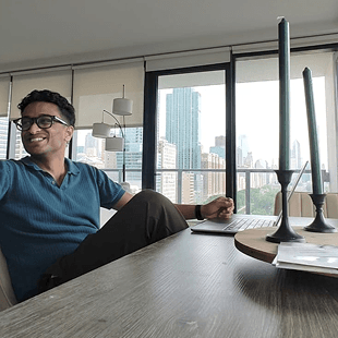Cyril sitting at a desk by a window