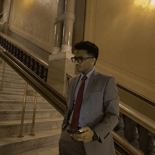 Cyril in a suit on a staircase